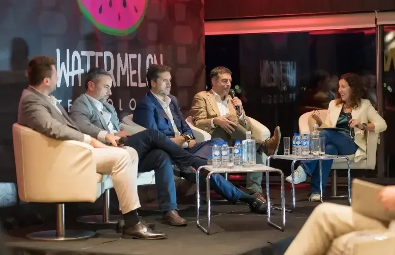 Panel de cinco invitados sentados en sillones en el escenario del Connect Conference