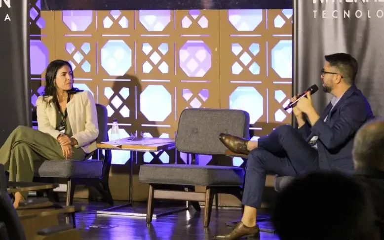Conversación entre una invitada y un moderador en el escenario