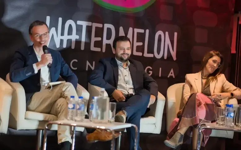 Tres panelistas sonrientes en el escenario del Connect Conference