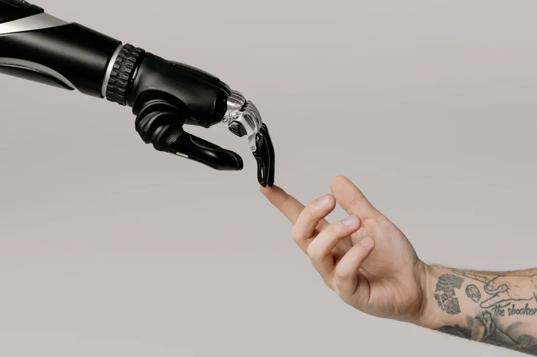 Mano robótica tocando el dedo de una mano humana