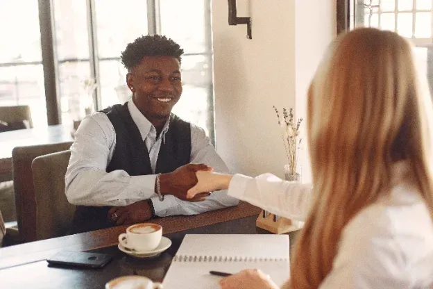 Profesional estrechando la mano de una clienta en una reunión